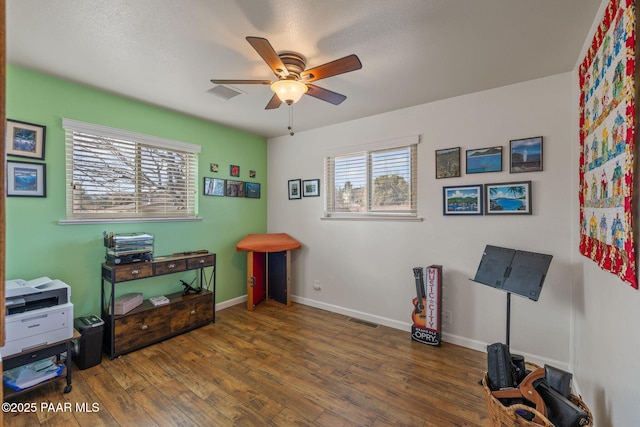 misc room with visible vents, baseboards, ceiling fan, and hardwood / wood-style flooring