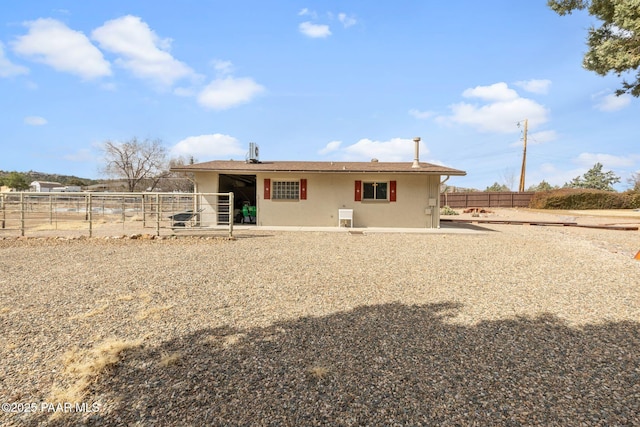 rear view of property featuring stucco siding