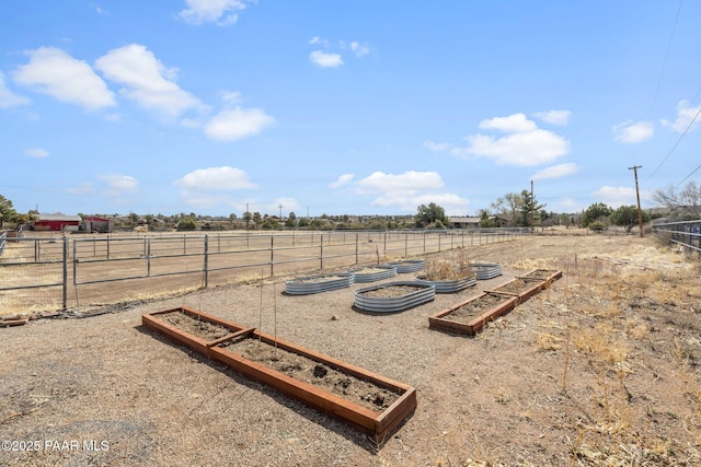 view of yard with a rural view, a vegetable garden, and fence