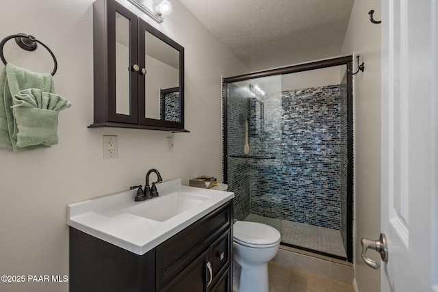 bathroom featuring a textured ceiling, vanity, a shower stall, and toilet