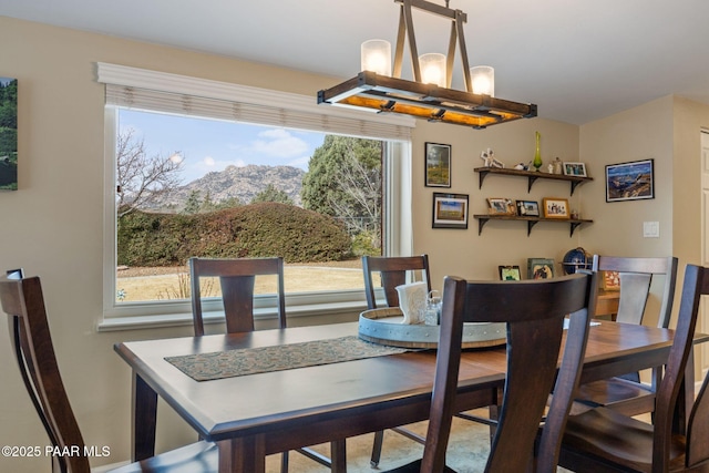 dining room featuring a mountain view and a chandelier