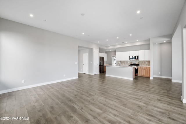 unfurnished living room with light hardwood / wood-style floors and sink