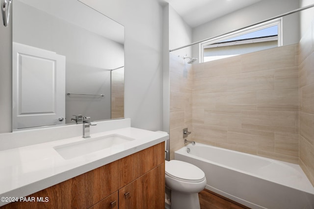 full bathroom with tiled shower / bath, toilet, vanity, and hardwood / wood-style flooring