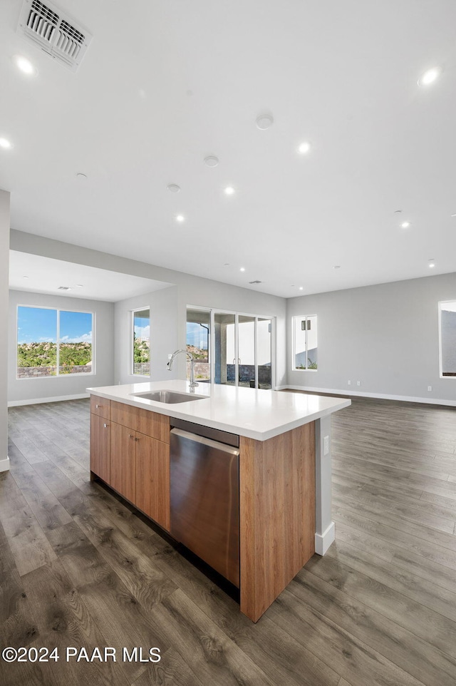 kitchen featuring a large island, dark hardwood / wood-style flooring, stainless steel dishwasher, and sink