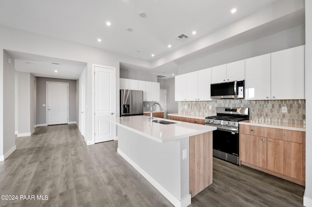 kitchen featuring sink, light hardwood / wood-style flooring, a kitchen island with sink, white cabinets, and appliances with stainless steel finishes