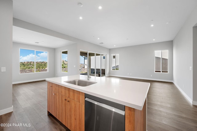 kitchen featuring dark hardwood / wood-style flooring, a kitchen island with sink, sink, and dishwasher