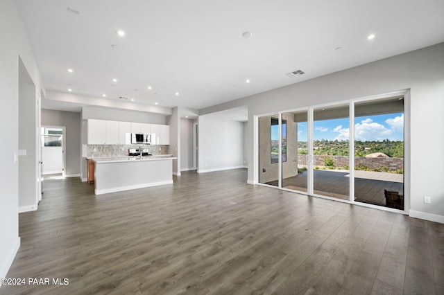 unfurnished living room with dark wood-type flooring