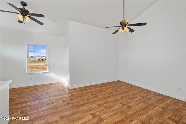 empty room with vaulted ceiling, ceiling fan, and light hardwood / wood-style floors