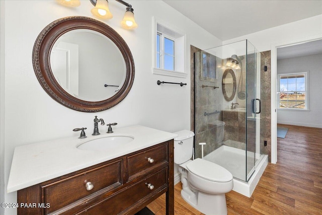 bathroom featuring walk in shower, vanity, toilet, and wood-type flooring