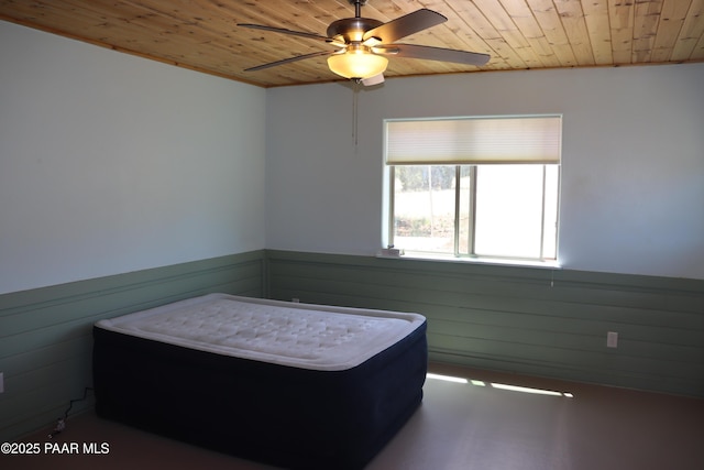 1155 W Half Moon Ct, Ash Fork, AZ 86320 - bedroom featuring wooden ceiling, a wainscoted wall, wood walls, and ceiling fan