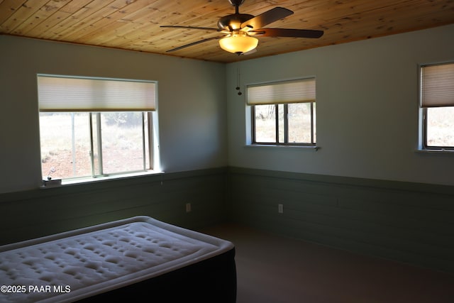 1155 W Half Moon Ct, Ash Fork, AZ 86320 - unfurnished bedroom featuring wood ceiling, multiple windows, wainscoting, and wood walls