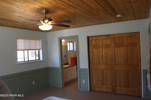 1155 W Half Moon Ct, Ash Fork, AZ 86320 - unfurnished bedroom featuring a wainscoted wall, wood ceiling, a sink, ensuite bathroom, and a closet