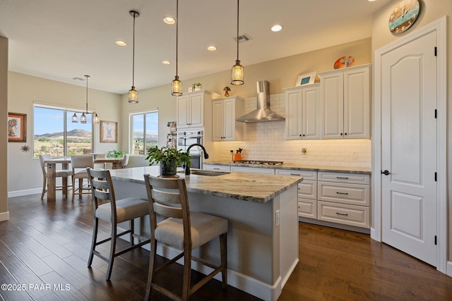 5313 Autumn Leaf Ln, Prescott, AZ 86301 - kitchen with wall chimney exhaust hood, a sink, decorative backsplash, a breakfast bar area, and stainless steel appliances