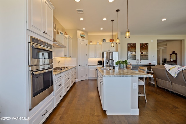 5313 Autumn Leaf Ln, Prescott, AZ 86301 - kitchen featuring appliances with stainless steel finishes, a breakfast bar area, recessed lighting, white cabinets, and decorative backsplash