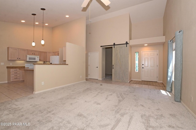 2091 E Oxford, Prescott Valley, AZ 86314 - unfurnished living room featuring high vaulted ceiling, light colored carpet, baseboards, ceiling fan, and a barn door
