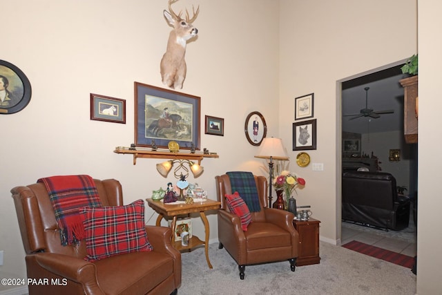 sitting room with ceiling fan and light colored carpet