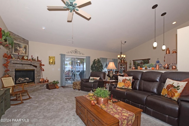 living room featuring ceiling fan with notable chandelier, a stone fireplace, light carpet, and vaulted ceiling