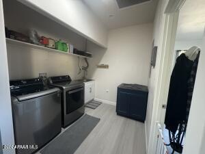 laundry room featuring washer and clothes dryer and light hardwood / wood-style flooring