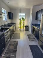 kitchen with stainless steel range, hardwood / wood-style flooring, and sink