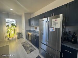 kitchen featuring stainless steel fridge and light hardwood / wood-style flooring