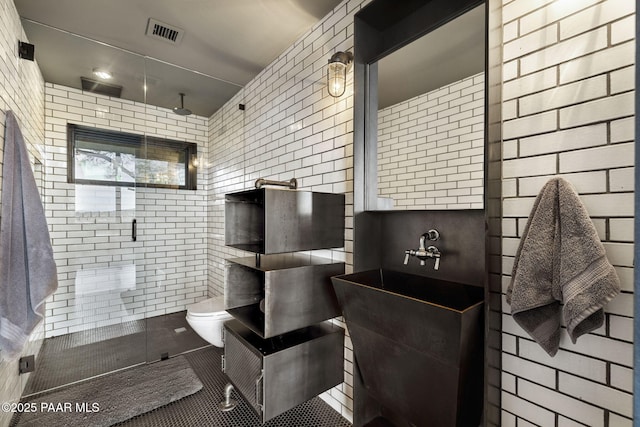 51 Rill Rd, Prescott, AZ 86305 - bathroom with tile walls, a stall shower, toilet, and tile patterned flooring