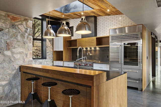 51 Rill Rd, Prescott, AZ 86305 - kitchen with stainless steel built in refrigerator, modern cabinets, butcher block counters, a kitchen bar, and finished concrete floors