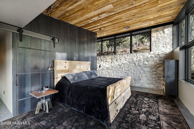 51 Rill Rd, Prescott, AZ 86305 - bedroom with wood ceiling, a barn door, and wooden walls