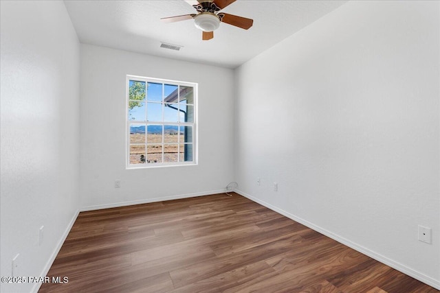 unfurnished room featuring wood finished floors, visible vents, baseboards, and ceiling fan