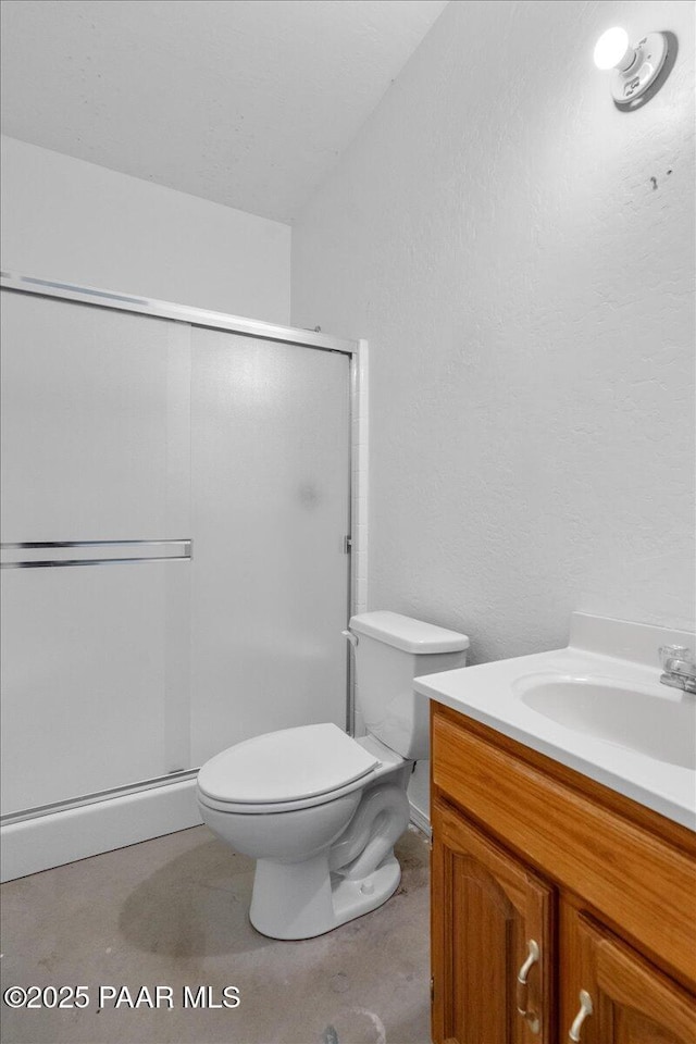 full bathroom with toilet, vanity, and a stall shower