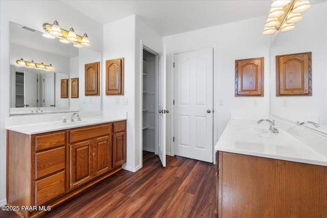 bathroom with two vanities, wood finished floors, and a sink