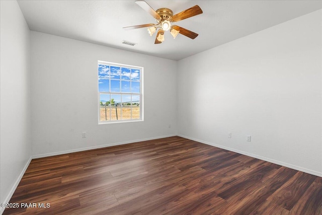 spare room featuring wood finished floors, visible vents, baseboards, and ceiling fan