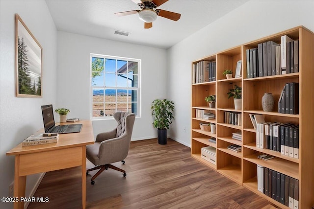 office space featuring wood finished floors, visible vents, baseboards, and ceiling fan