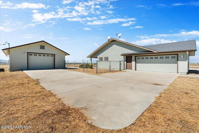 ranch-style house with concrete driveway and fence
