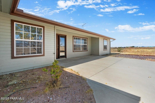 view of exterior entry with a patio area
