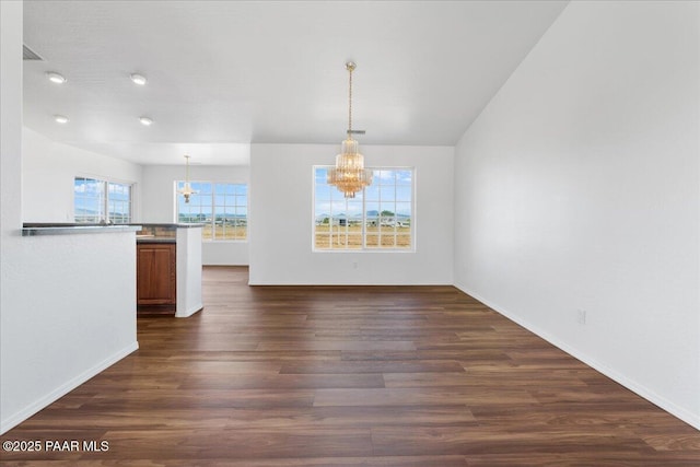 unfurnished dining area featuring a chandelier, baseboards, dark wood-type flooring, and recessed lighting