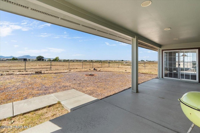 view of patio featuring fence and a mountain view