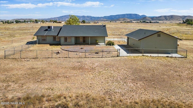 rear view of property with a gate, a mountain view, and a fenced backyard