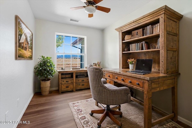 office featuring light wood-type flooring, visible vents, a ceiling fan, and baseboards