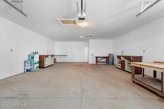garage featuring water heater, a workshop area, and a garage door opener