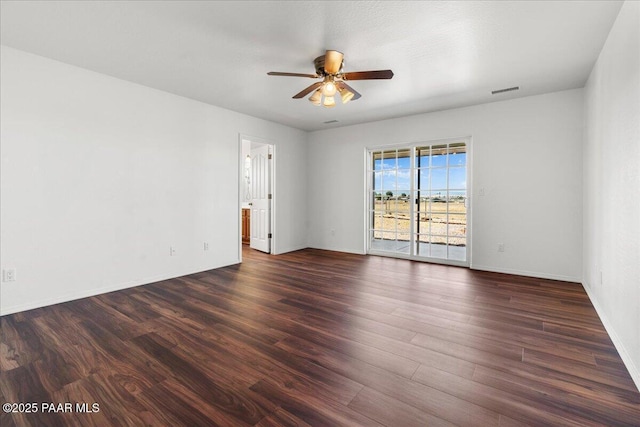 empty room featuring baseboards, a ceiling fan, and dark wood-style floors