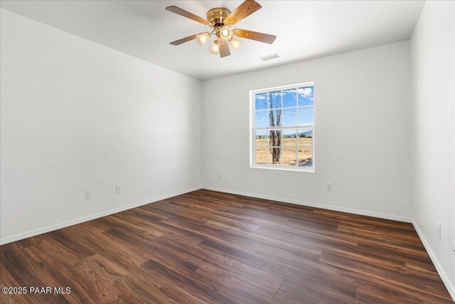 unfurnished room featuring baseboards, visible vents, dark wood-type flooring, and ceiling fan