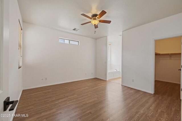 1735 Oro Dr, Cottonwood, AZ 86326 - unfurnished bedroom with a spacious closet, wood finished floors, baseboards, ensuite bathroom, and a ceiling fan