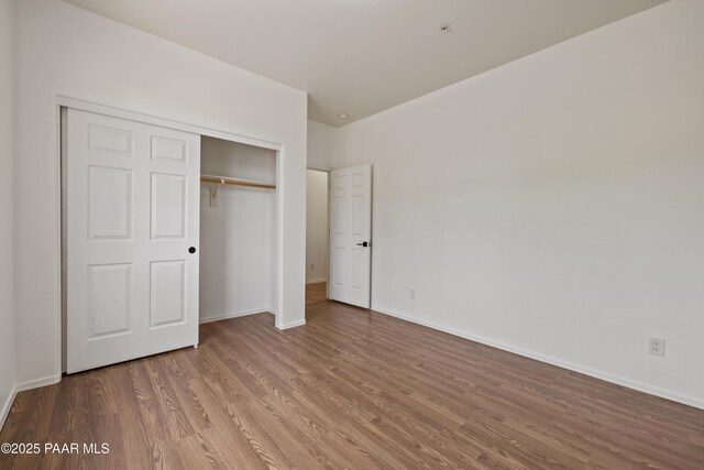 1735 Oro Dr, Cottonwood, AZ 86326 - unfurnished bedroom with wood finished floors, a closet, and baseboards
