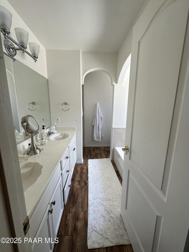 6217 N Little Papoose Dr, Prescott Valley, AZ 86314 - full bathroom with double vanity, a bath, wood finished floors, and a textured ceiling