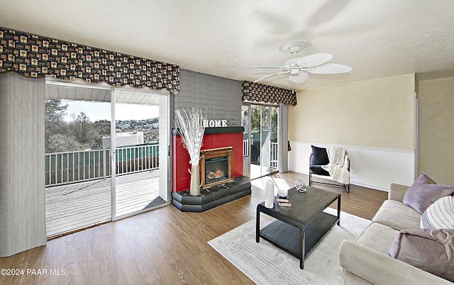 living room with a fireplace, wood-type flooring, and ceiling fan