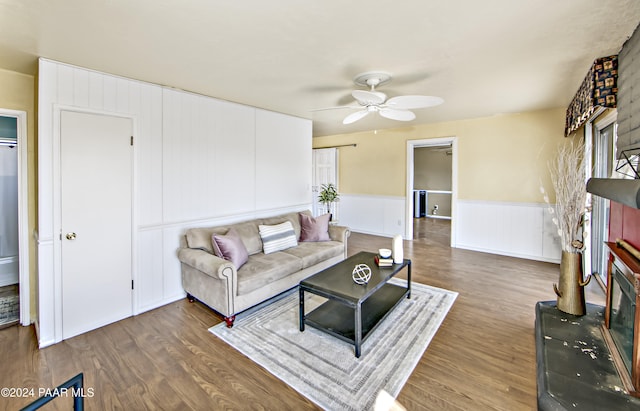 living room featuring ceiling fan and dark hardwood / wood-style flooring