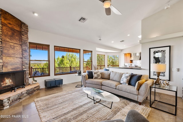 13175 N Bull Run Rd, Prescott, AZ 86305 - living area with healthy amount of natural light, a ceiling fan, a stone fireplace, vaulted ceiling, and tile patterned flooring