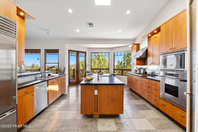13175 N Bull Run Rd, Prescott, AZ 86305 - kitchen featuring built in appliances, a sink, dark countertops, backsplash, and an island with sink