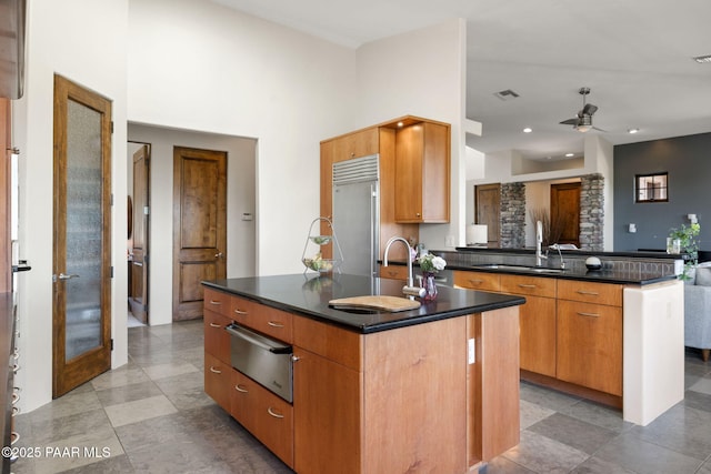 13175 N Bull Run Rd, Prescott, AZ 86305 - kitchen with a warming drawer, stainless steel built in refrigerator, dark countertops, a peninsula, and ceiling fan