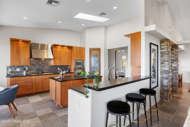 13175 N Bull Run Rd, Prescott, AZ 86305 - kitchen with wall chimney exhaust hood, appliances with stainless steel finishes, dark countertops, tasteful backsplash, and a center island